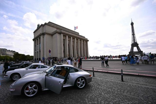 Participants park their car at the Trocadero, with the Eiffel Tower seen in the background, during the 19th Summer parade of vintage vehicles in Paris on July 19, 2026. (Photo by LOU BENOIST / AFP)