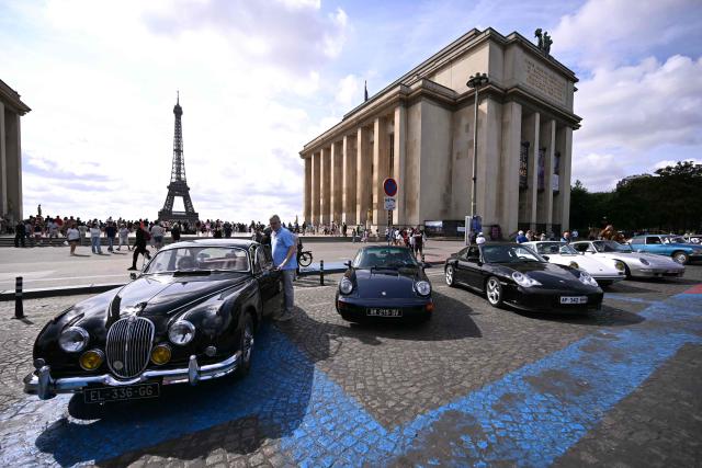 Participants park their car at the Trocadero, with the Eiffel Tower seen in the background, during the 19th Summer parade of vintage vehicles in Paris on July 19, 2026. (Photo by LOU BENOIST / AFP)