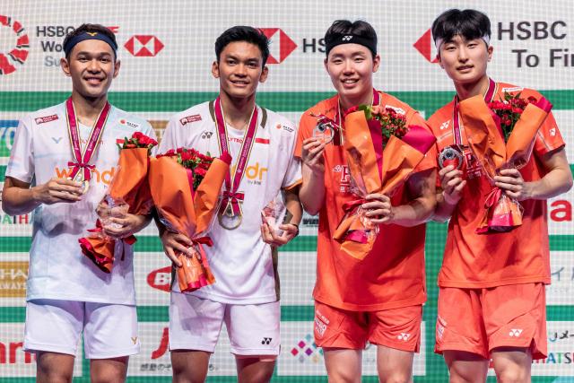 Gold medallists Indonesia’s Fajar Alfian and Muhammad Shohibul Fikri (L) and silver medallists South Koreaґs Kim Won-ho and Seo Seung-jae pose on the podium after their men's doubles final match of the Japan Open badminton tournament at Tokyo Gymnasium in Tokyo on July 19, 2026. (Photo by Yuichi YAMAZAKI / AFP)