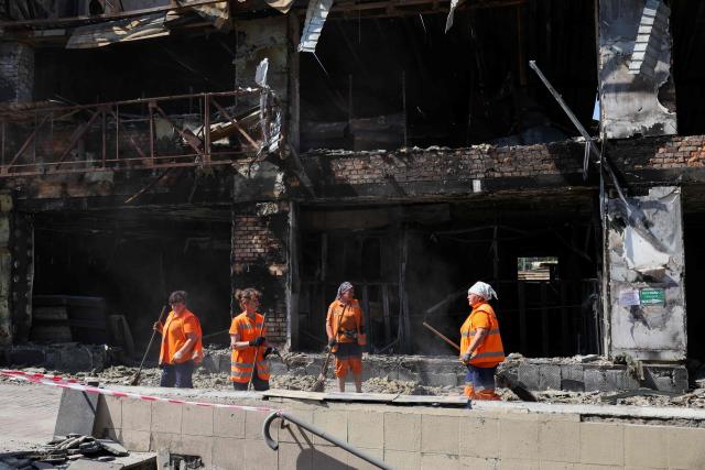 Communal workers clear debris near a shopping mall damaged by missile strikes in Kyiv on July 19, 2026, amid the Russian invasion of Ukraine. Russian missiles rocked Ukraine's capital overnight, damaging residential buildings and wounding at least two people a day after Kyiv launched a wave of drone strikes deep into Russian territory. (Photo by Serhii Okunev / AFP)