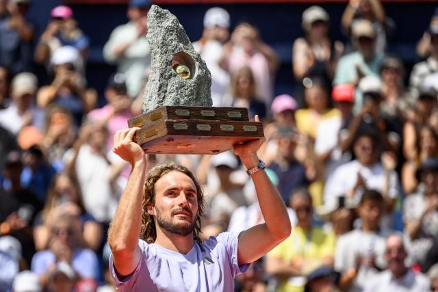 Greece's Stefanos Tsitsipas raises the trophy following his victory against Belgium's Raphael Collignon during their men's singles final match at the Swiss Open tennis tournament in Gstaad, on July 19, 2026. (Photo by Fabrice COFFRINI / AFP)