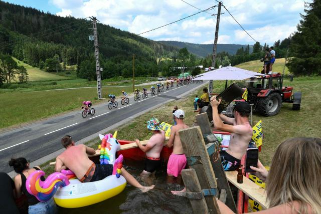 The pack of riders (peloton) cycles during the 15th stage of the 113th edition of the Tour de France cycling race, 183,9 km between Champagnole and Plateau de Solaison in the Jura mountains, on July 19, 2026. (Photo by Jeff PACHOUD / AFP)