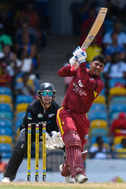 Gudakesh Motie (R) of West Indies hits 6 as Tom Latham (L) of New Zealand watches during the 4th One-Day International (ODI) cricket match between West Indies and New Zealand at Kensington Oval in Bridgetown, Barbados on July 19, 2026. (Photo by Randy Brooks / AFP)