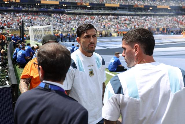 Argentina's midfielder #05 Leandro Paredes (C) and midfielder #07 Rodrigo De Paul (R) inspect the pitch ahead of the 2026 World Cup football tournament final match between Spain and Argentina at the New York/New Jersey Stadium in East Rutherford on July 19, 2026.  (Photo by PATRICIA DE MELO MOREIRA / AFP)