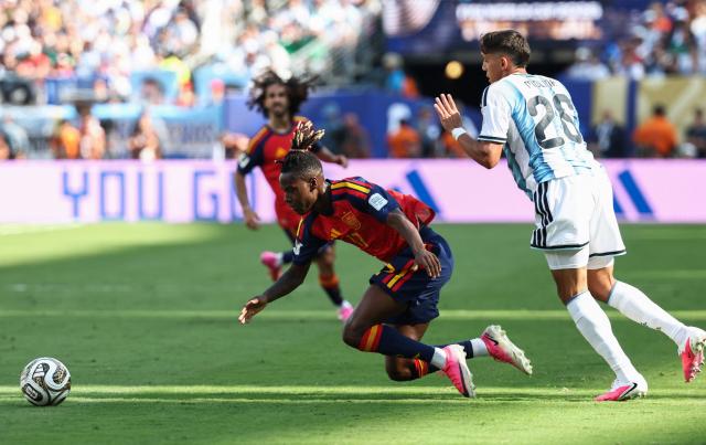 Spain's forward #17 Nico Williams falls past Argentina's defender #26 Nahuel Molina during the 2026 World Cup football tournament final match between Spain and Argentina at the New York/New Jersey Stadium in East Rutherford on July 19, 2026.  (Photo by FRANCK FIFE / AFP)