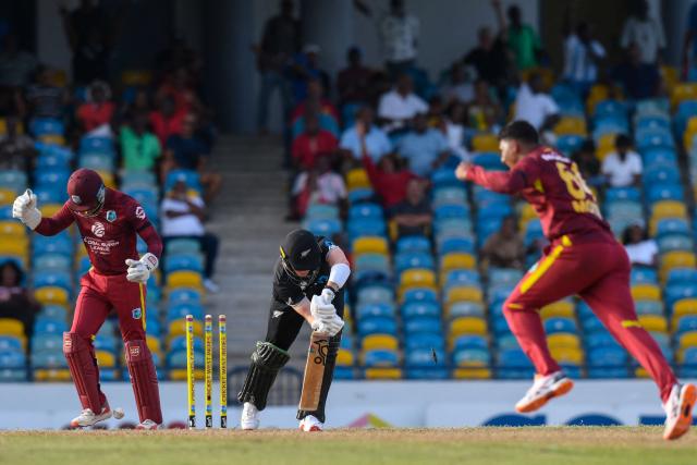 Matt Fisher (C) of New Zealand is bowled by Gudakesh Motie (R) of West Indies during the 4th One-Day International (ODI) cricket match between West Indies and New Zealand at Kensington Oval in Bridgetown, Barbados on July 19, 2026. (Photo by Randy Brooks / AFP)