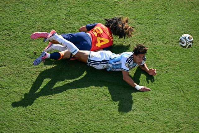 Spain's defender #24 Marc Cucurella and Argentina's forward #17 Giuliano Simeone fall while fighting for the ball during the 2026 World Cup football tournament final match between Spain and Argentina at the New York/New Jersey Stadium in East Rutherford on July 19, 2026.  (Photo by Jewel SAMAD / AFP)