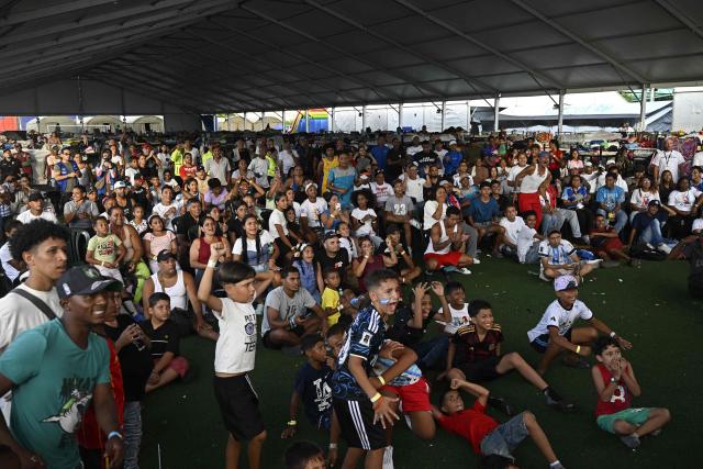People affected by the June 24 earthquakes watch the FIFA World Cup 2026 final football match between Spain and Argentina on a giant screen at a temporary shelter in Maiquetia, La Guaira state, Venezuela, on July 19, 2026. (Photo by Federico PARRA / AFP)