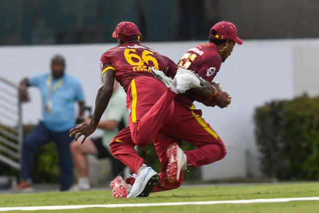 Akeem Auguste (R) of West Indies collides with teammate Justin Greaves and drops a catch to dismiss Mitchell Santner of New Zealand during the 4th One-Day International (ODI) cricket match between West Indies and New Zealand at Kensington Oval in Bridgetown, Barbados on July 19, 2026. (Photo by Randy Brooks / AFP)