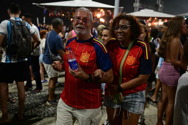 People wearing Spanish jerseys are seen after the FIFA World Cup final football match between Spain and Argentina at Copacabana beach in Rio de Janeiro, Brazil, on July 19, 2026. Spain won by 1-0. (Photo by Pablo PORCIUNCULA / AFP)