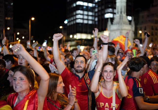 Spain's supporters celebrate victory after the 2026 World Cup final match between Spain and Argentina displayed on giant screens at Colon square's fan zone in Madrid, on July 19, 2026. (Photo by Paul Hanna / AFP)