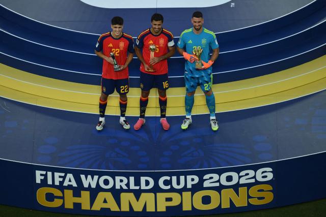 (From L) Spain's defender #22 Pau Cubarsi, Spain's midfielder #16 Rodri and Spain's goalkeeper #23 Unai Simon celebrate with their trophies after the 2026 World Cup football tournament final match between Spain and Argentina at the New York/New Jersey Stadium in East Rutherford on July 19, 2026.  (Photo by ANGELA WEISS / AFP)