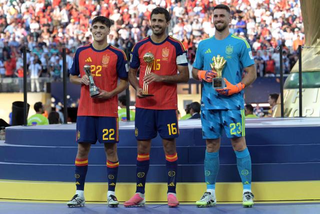 Spain's defender #22 Pau Cubarsi, Spain's midfielder #16 Rodri and Spain's goalkeeper #23 Unai Simon pose on the podium after respectively receiving the Young Player, Golden Ball, Golden Glove awards during the award ceremony of the 2026 World Cup football tournament final match between Spain and Argentina at the New York/New Jersey Stadium in East Rutherford on July 19, 2026.  (Photo by JUAN MABROMATA / AFP)