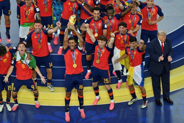 Spain's midfielder #16 Rodri (front C) lifts the trophy with Spain's players next to US President Donald Trump (R) during the final ceremony after the 2026 World Cup football tournament final match between Spain and Argentina at the New York/New Jersey Stadium in East Rutherford on July 19, 2026.  (Photo by ANGELA WEISS / AFP)