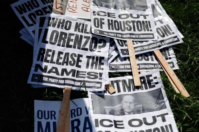 Signs are seen in the grass during a protest against the death of Mexican migrant Lorenzo Salgado Araujo, who was fatally shot by a US immmigration officer, in Houston, Texas, on July 19, 2026. The US Department of Homeland Security said on July 14 that Salgado Araujo, 52, had been the target of an operation by Immigration and Customs Enforcement (ICE) agents in Houston and had "attempted to evade arrest." Witnesses to the fatal shooting have disputed the official account of events, saying the man never tried to run over the federal officer who shot him, their lawyer said on July 17. (Photo by Mark Felix / AFP)
