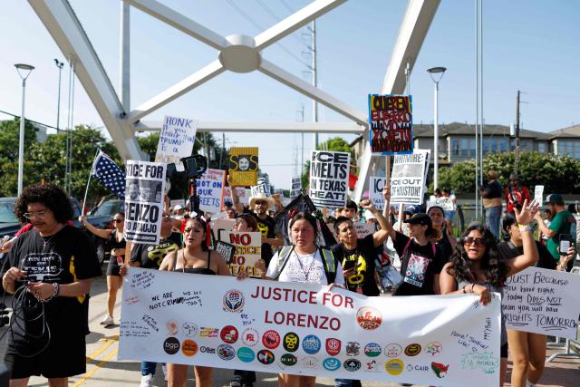 People hold signs on a bridge to protest the death of Mexican migrant Lorenzo Salgado Araujo, who was fatally shot by a US immmigration officer, in Houston, Texas, on July 19, 2026. The US Department of Homeland Security said on July 14 that Salgado Araujo, 52, had been the target of an operation by Immigration and Customs Enforcement (ICE) agents in Houston and had "attempted to evade arrest." Witnesses to the fatal shooting have disputed the official account of events, saying the man never tried to run over the federal officer who shot him, their lawyer said on July 17. (Photo by Mark Felix / AFP)