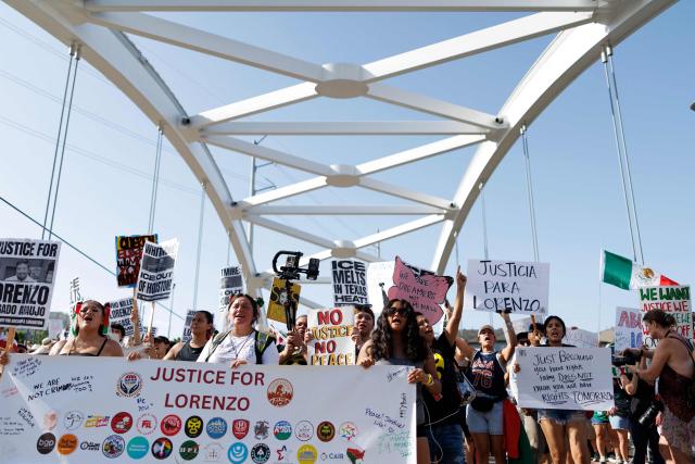 People hold signs on a bridge to protest the death of Mexican migrant Lorenzo Salgado Araujo, who was fatally shot by a US immmigration officer, in Houston, Texas, on July 19, 2026. The US Department of Homeland Security said on July 14 that Salgado Araujo, 52, had been the target of an operation by Immigration and Customs Enforcement (ICE) agents in Houston and had "attempted to evade arrest." Witnesses to the fatal shooting have disputed the official account of events, saying the man never tried to run over the federal officer who shot him, their lawyer said on July 17. (Photo by Mark Felix / AFP)