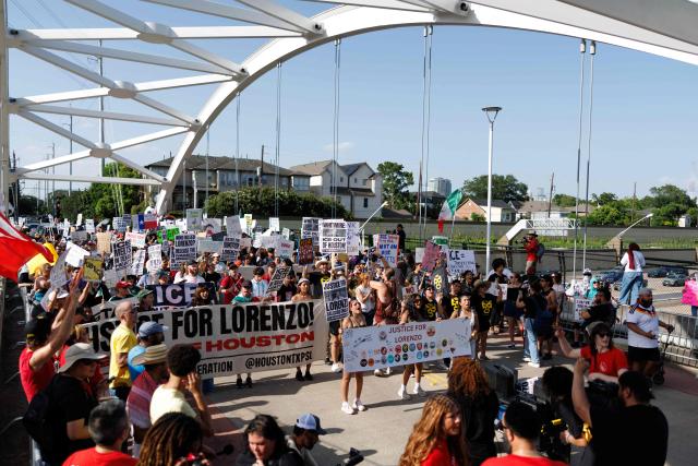 People hold signs on a bridge to protest the death of Mexican migrant Lorenzo Salgado Araujo, who was fatally shot by a US immmigration officer, in Houston, Texas, on July 19, 2026. The US Department of Homeland Security said on July 14 that Salgado Araujo, 52, had been the target of an operation by Immigration and Customs Enforcement (ICE) agents in Houston and had "attempted to evade arrest." Witnesses to the fatal shooting have disputed the official account of events, saying the man never tried to run over the federal officer who shot him, their lawyer said on July 17. (Photo by Mark Felix / AFP)