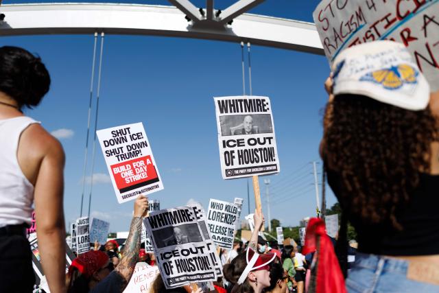 People hold signs on a bridge to protest the death of Mexican migrant Lorenzo Salgado Araujo, who was fatally shot by a US immmigration officer, in Houston, Texas, on July 19, 2026. The US Department of Homeland Security said on July 14 that Salgado Araujo, 52, had been the target of an operation by Immigration and Customs Enforcement (ICE) agents in Houston and had "attempted to evade arrest." Witnesses to the fatal shooting have disputed the official account of events, saying the man never tried to run over the federal officer who shot him, their lawyer said on July 17. (Photo by Mark Felix / AFP)