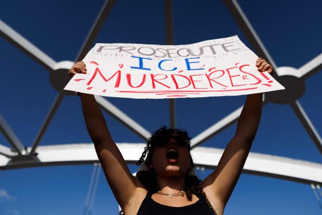 A person holds a sign reading "prosecute ICE murderers" as people gather on a bridge to protest the death of Mexican migrant Lorenzo Salgado Araujo, who was fatally shot by a US immmigration officer, in Houston, Texas, on July 19, 2026. The US Department of Homeland Security said on July 14 that Salgado Araujo, 52, had been the target of an operation by Immigration and Customs Enforcement (ICE) agents in Houston and had "attempted to evade arrest." Witnesses to the fatal shooting have disputed the official account of events, saying the man never tried to run over the federal officer who shot him, their lawyer said on July 17. (Photo by Mark Felix / AFP)