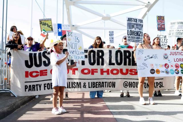A girl holds a sign and chants on a bridge along with others to protest the death of Mexican migrant Lorenzo Salgado Araujo, who was fatally shot by a US immmigration officer, in Houston, Texas, on July 19, 2026. The US Department of Homeland Security said on July 14 that Salgado Araujo, 52, had been the target of an operation by Immigration and Customs Enforcement (ICE) agents in Houston and had "attempted to evade arrest." Witnesses to the fatal shooting have disputed the official account of events, saying the man never tried to run over the federal officer who shot him, their lawyer said on July 17. (Photo by Mark Felix / AFP)