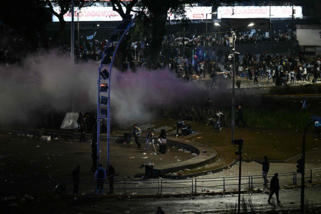 Argentina's fans run as riot police fire tear gas during clashes at the Obelisk after Argentina lost the FIFA World Cup final football match against Spain in Buenos Aires on July 19, 2026. Spain won by 1-0. (Photo by Luis ROBAYO / AFP)
