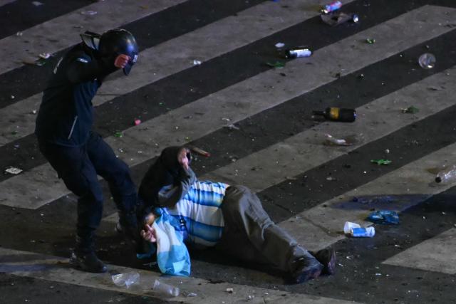 A riot police officer strikes an Argentina fan during clashes at the Obelisk after Argentina lost the FIFA World Cup final football match against Spain in Buenos Aires on July 19, 2026. Spain won by 1-0. (Photo by Luis ROBAYO / AFP)
