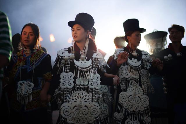 People walk hand in hand as they celebrate the Torch Festival, held by the Yi ethnic minority, in Puge County, Liangshan Prefecture, in China’s southwest Sichuan Province on July 19, 2026. The celebrations took in traditional folk activities such as horse racing, bullfighting, and dancing and singing around bonfires. (Photo by CN-STR / AFP) / China OUT