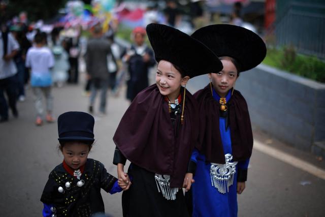 People make their way to a gathering to celebrate the Torch Festival, held by the Yi ethnic minority, in Puge County, Liangshan Prefecture, in China’s southwest Sichuan Province on July 19, 2026. The celebrations took in traditional folk activities such as horse racing, bullfighting, and dancing and singing around bonfires. (Photo by CN-STR / AFP) / China OUT