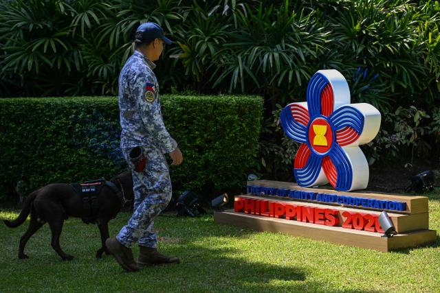 A member of the Philippine Coast Guard and his working dog patrol the compounds of the International Media Center for the 59th ASEAN Foreign Ministers' Meeting and Related Meetings in Manila on July 20, 2026. (Photo by Jam STA ROSA / AFP)