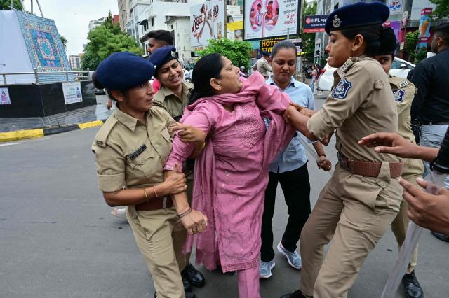 Police personnel detain a supporter of the Cockroach Janta Party (CJP) during a protest demanding the resignation of India's Education Minister Dharmendra Pradhan over alleged NEET examination irregularities in Ahmedabad on July 20, 2026. (Photo by Shammi MEHRA / AFP)