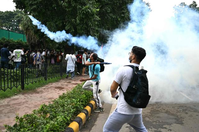 Activists and supporters of the Cockroach Janta Party (CJP) throw back tear gas shells during a protest demanding the resignation of India's Education Minister Dharmendra Pradhan over alleged NEET examination irregularities in New Delhi on July 20, 2026. India's riot police baton-charged protesters in New Delhi as they tried to march to parliament on July 20, escalating a protest over irregularities in major examinations. (Photo by Sajjad HUSSAIN / AFP)