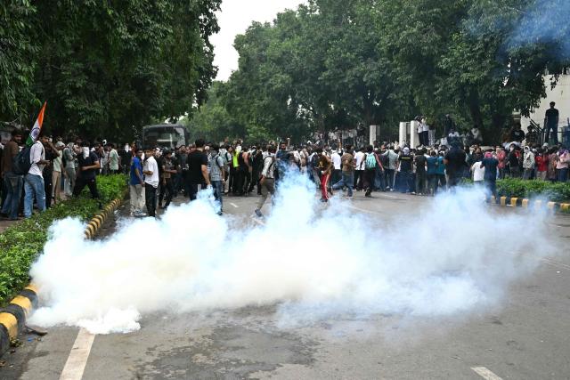 Activists and supporters of the Cockroach Janta Party (CJP) dispersed after police fire tear gas shells during a protest demanding the resignation of India's Education Minister Dharmendra Pradhan over alleged NEET examination irregularities in New Delhi on July 20, 2026. India's riot police baton-charged protesters in New Delhi as they tried to march to parliament on July 20, escalating a protest over irregularities in major examinations. (Photo by Sajjad HUSSAIN / AFP)