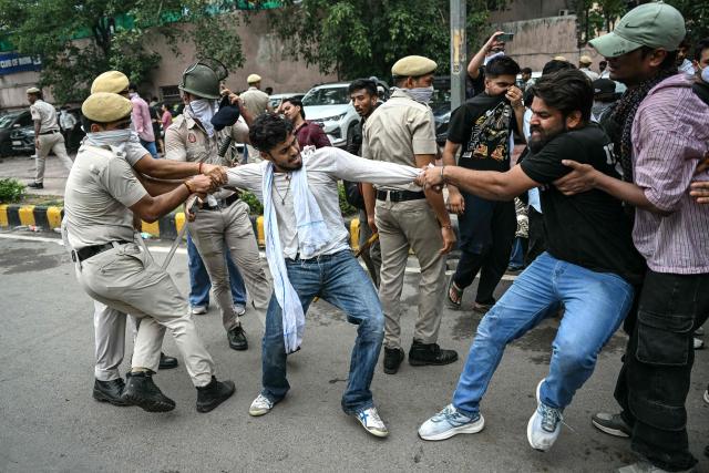 Activists and supporters of the Cockroach Janta Party (CJP) clash with police personnel during a protest demanding the resignation of India's Education Minister Dharmendra Pradhan over alleged NEET exam irregularities in New Delhi on July 20, 2026. India's riot police baton-charged protesters in New Delhi as they tried to march to parliament on July 20, escalating a protest over irregularities in major examinations. (Photo by Sajjad HUSSAIN / AFP)