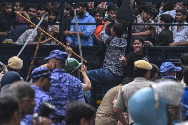Police personnel baton-charge to disperse activists and supporters of the Cockroach Janta Party (CJP) during a protest demanding the resignation of India's Education Minister Dharmendra Pradhan over alleged NEET exam irregularities in New Delhi on July 20, 2026. Indian police fired tear gas and baton-charged protesters in New Delhi on July 20 as they tried to march on parliament to demand the resignation of the education minister over irregularities in major examinations. (Photo by Arun SANKAR / AFP)