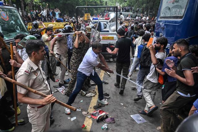 Police personnel baton-charge to disperse activists and supporters of the Cockroach Janta Party (CJP) during a protest demanding the resignation of India's Education Minister Dharmendra Pradhan over alleged NEET exam irregularities in New Delhi on July 20, 2026. Indian police fired tear gas and baton-charged protesters in New Delhi on July 20 as they tried to march on parliament to demand the resignation of the education minister over irregularities in major examinations. (Photo by Arun SANKAR / AFP)