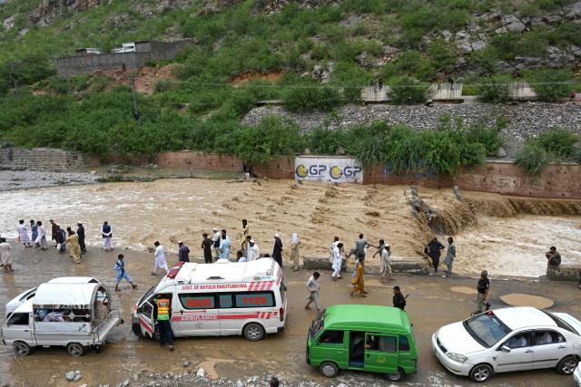 Commuters wait as floodwater swamps a road following heavy monsoon rains at Landi Kotal in Pakistan's Khyber Pakhtunkhwa province on July 20, 2026. (Photo by Abdul MAJEED / AFP)