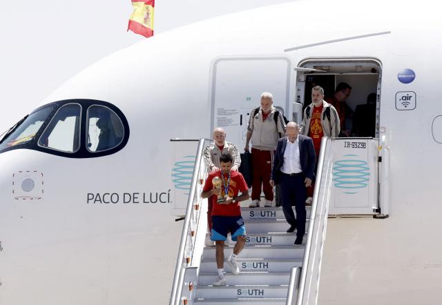 Spain's captain Rodri holds their trophy ahead of Spain's coach Luis de la Fuente as they disembark their plane upon their arrival from the US after winning the 2026 World Cup, in Madrid Barajas' airport, on July 20, 2026. Spain's World Cup winners come back home to a heroes' welcome in Madrid, where a million fans are expected to greet them after a night of raucous celebrations across the country. (Photo by Oscar DEL POZO / AFP)