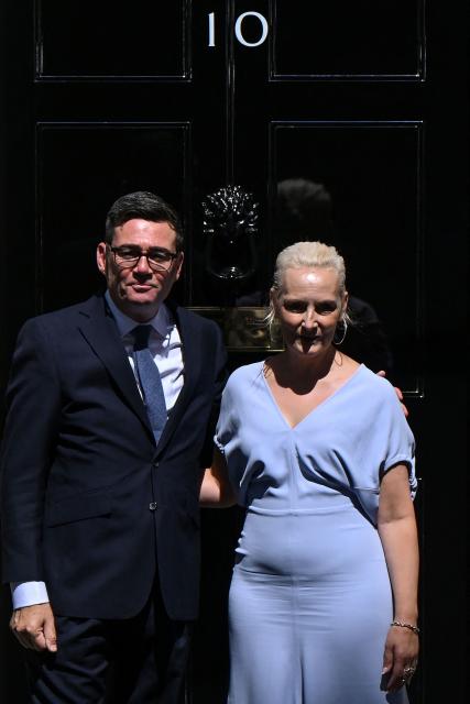 Britain's new Prime Minister Andy Burnham (L) and his wife Marie-France van Heel pose on the steps of 10 Downing Street in central London on July 20, 2026, after being asked by the king to form the next government. (Photo by JUSTIN TALLIS / AFP)