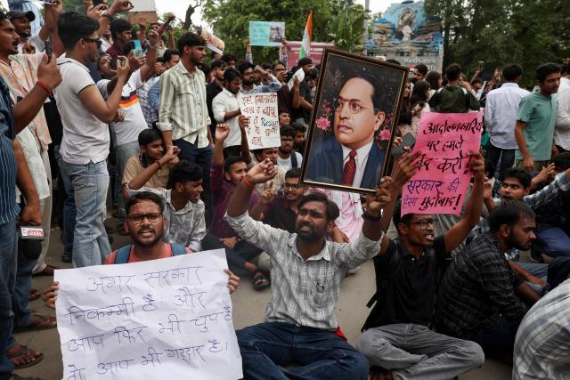 Banaras Hindu University (BHU) students in solidarity with Cockroach Janta Party (CJP) hold a portrait of India's social reformer and architect of its constitution B.R. Ambedkar, during a protest demanding the resignation of the country's Education Minister Dharmendra Pradhan over alleged NEET exam irregularities, in Varanasi on July 20, 2026. Indian police fired tear gas and baton-charged protesters in New Delhi on July 20, as they tried to march on parliament to demand the resignation of the education minister over irregularities in major examinations. (Photo by Niharika KULKARNI / AFP)