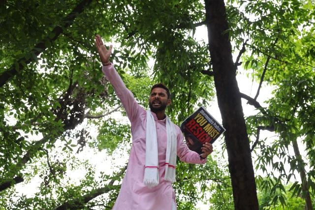 A Cockroach Janta Party (CJP) supporter holds a placard during a protest demanding the resignation of India's Education Minister Dharmendra Pradhan over alleged NEET exam irregularities in Varanasi on July 20, 2026. Indian police fired tear gas and baton-charged protesters in New Delhi on July 20, as they tried to march on parliament to demand the resignation of the education minister over irregularities in major examinations. (Photo by Niharika KULKARNI / AFP)