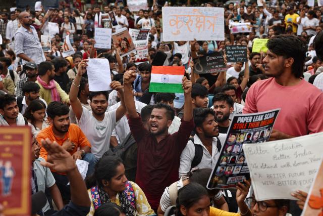 Banaras Hindu University (BHU) students in solidarity with Cockroach Janta Party (CJP) hold placards during a protest demanding the resignation of India's Education Minister Dharmendra Pradhan over alleged NEET exam irregularities in Varanasi on July 20, 2026. Indian police fired tear gas and baton-charged protesters in New Delhi on July 20, as they tried to march on parliament to demand the resignation of the education minister over irregularities in major examinations. (Photo by Niharika KULKARNI / AFP)