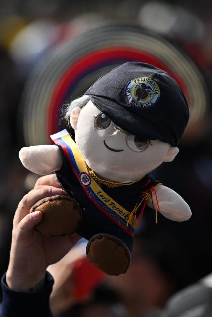 A supporters of Colombia's President Gustavo Petro holds up a doll depicting hims before his speech and a military parade to commemorate Colombia's Independence Day in Bogota, on July 20, 2026. (Photo by LUIS ACOSTA / AFP)