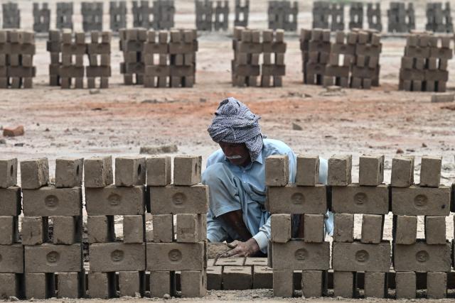 A man works at a brick kiln in Sheikhupura, in Pakistan’s Punjab province on July 20, 2026. (Photo by Arif ALI / AFP)