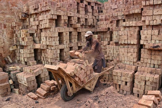 A man works at a brick kiln in Sheikhupura, in Pakistan’s Punjab province on July 20, 2026. (Photo by Arif ALI / AFP)