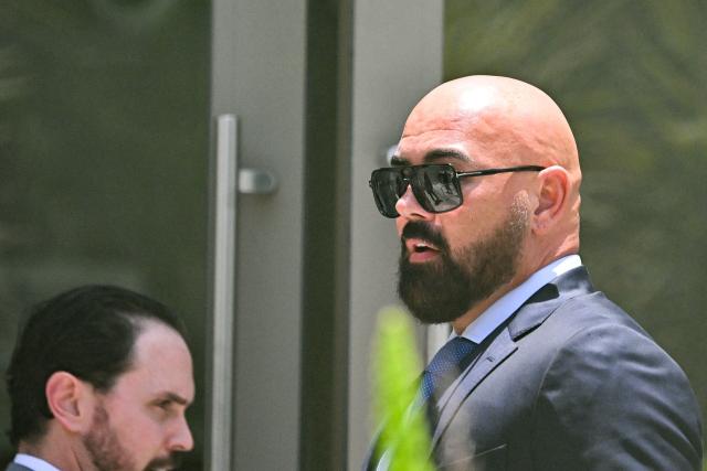 Joseph D. McBride (R), attorney for Andrew Tate and Tristan Tate, arrives ahead of the hearing for the Tate brothers at the C. Clyde Atkins US Courthouse in Miami, Florida, on July 20, 2026. Radical social media influencer Andrew Tate and his brother Tristan were in custody in the US on July 19,  officials said, as Britain seeks their extradition to face new charges of rape, sex trafficking and assault. (Photo by CHANDAN KHANNA / AFP)