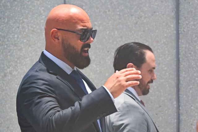 Joseph D. McBride (L), attorney for Andrew Tate and Tristan Tate, arrives ahead of the hearing for the Tate brothers at the C. Clyde Atkins US Courthouse in Miami, Florida, on July 20, 2026. Radical social media influencer Andrew Tate and his brother Tristan were in custody in the US on July 19,  officials said, as Britain seeks their extradition to face new charges of rape, sex trafficking and assault. (Photo by CHANDAN KHANNA / AFP)