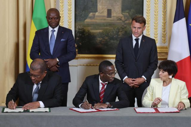 Gabon's President Brice Oligui Nguema (2ndL) and France's President Emmanuel Macron watch CEO of the Eramet Group, Christel Bories (R), General Director of Ogooue Mining company (COMILOG) Leod Paul Batolo (L) and Gabon's Mining Minister Sosthene Nguema Nguema signing a Memorandum of Understanding related to manganese value chain on the sidelines of the state visit of Gabon's President at the Elysee Palace in Paris on July 20, 2026. (Photo by Ludovic MARIN / POOL / AFP)