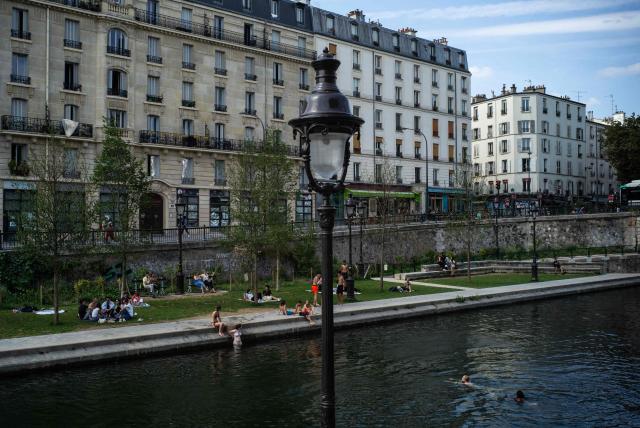 Peoples enjoy to swimming into the Canal Saint-Martin during summer in Paris, on July 20, 2026. (Photo by JULIEN DE ROSA / AFP)