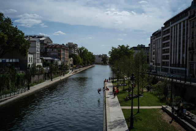A man dives into the Canal Saint-Martin during summer in Paris, on July 20, 2026. (Photo by JULIEN DE ROSA / AFP)